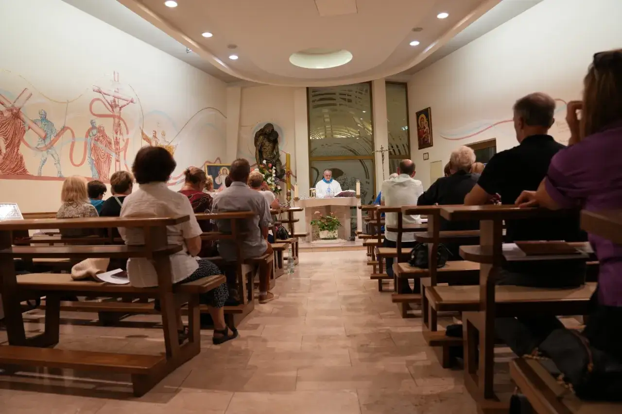 Rodzic z dzieckiem siedzący w ławce w kościele, spokojna atmosfera