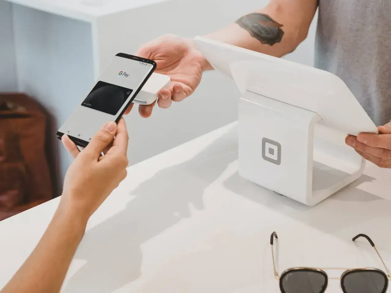 Szybkie zakupy? Tak, tak właśnie jak płacić telefonem w sklepie. Klient zbliża smartfon z Google Pay do terminala płatniczego.