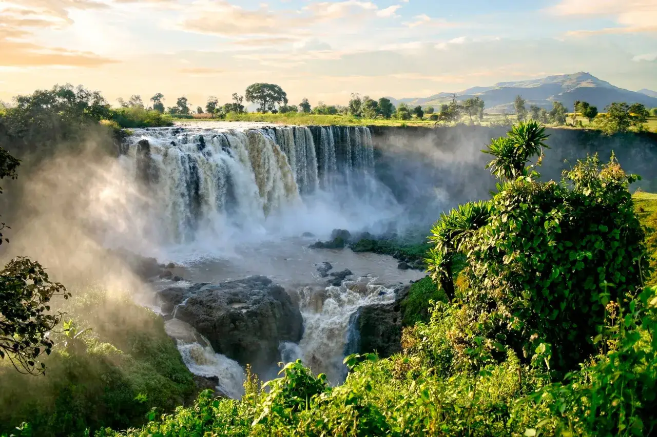 Wodospad Nilu Błękitnego, jedna z głównych etiopia atrakcje, w mgiełce i słońcu. Bujna zieleń otacza kaskady.