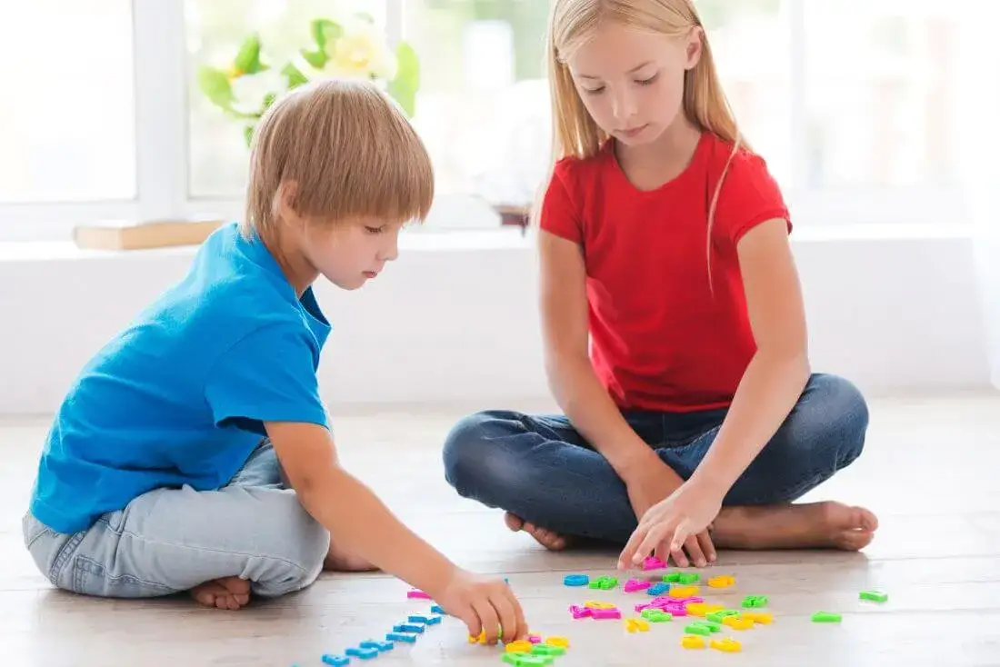 dziecko rozwiązujące zagadkę matematyczną z klockami lub kolorowymi liczmanami