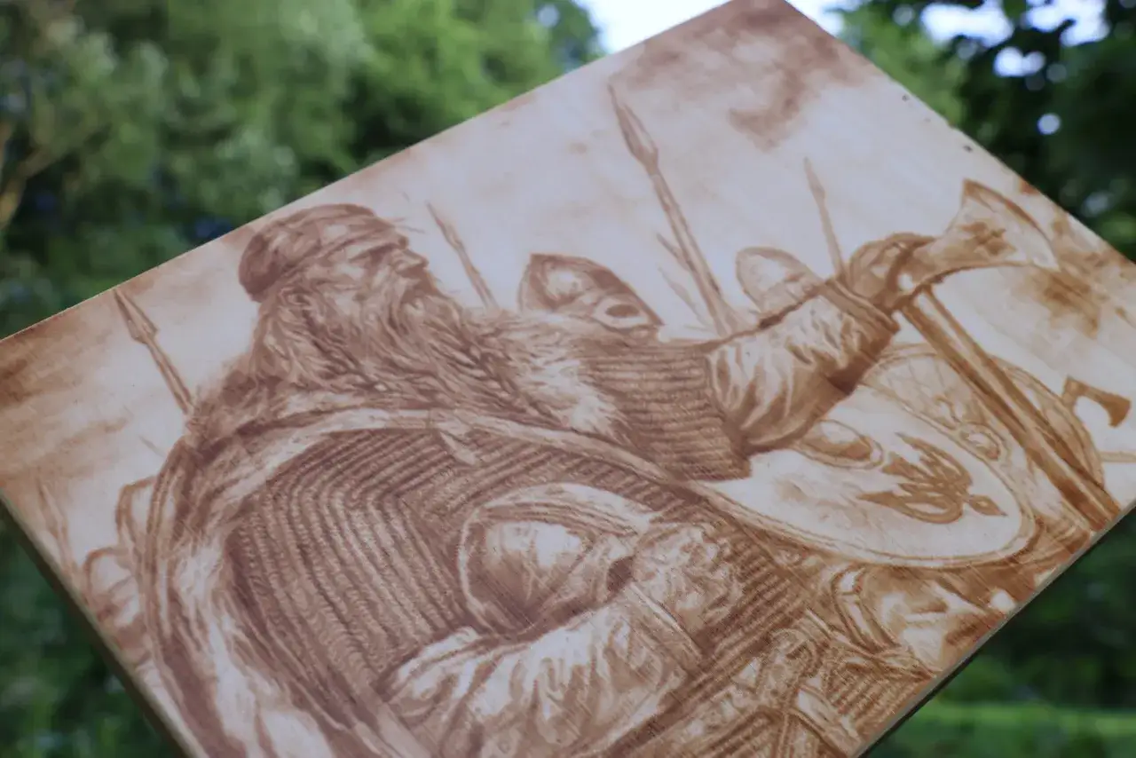 Wypalanie w drewnie przedstawia wiking&oacute;w w zbrojach, z toporem i tarczami. Ich brody i zbroje są szczeg&oacute;łowo oddane.