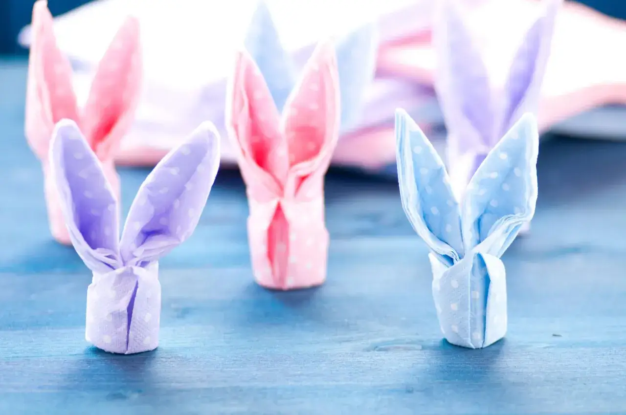 Jak zrobić zajączka z serwetki? Urocze, pastelowe zajączki z serwetek na niebieskim tle.