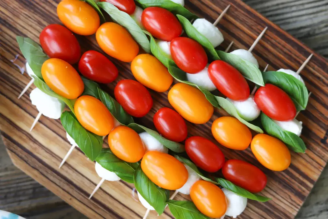 Kolorowe szaszłyki z pomidorków koktajlowych, mozzarelli i bazylii – idealna zdrowa przekąska dla dzieci.