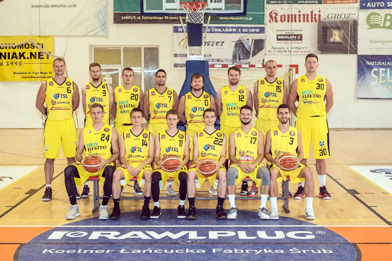Drużyna koszykarzy w ż&oacute;łtych strojach, pozuje do zdjęcia. W sumie 15 os&oacute;b gra w kosza.