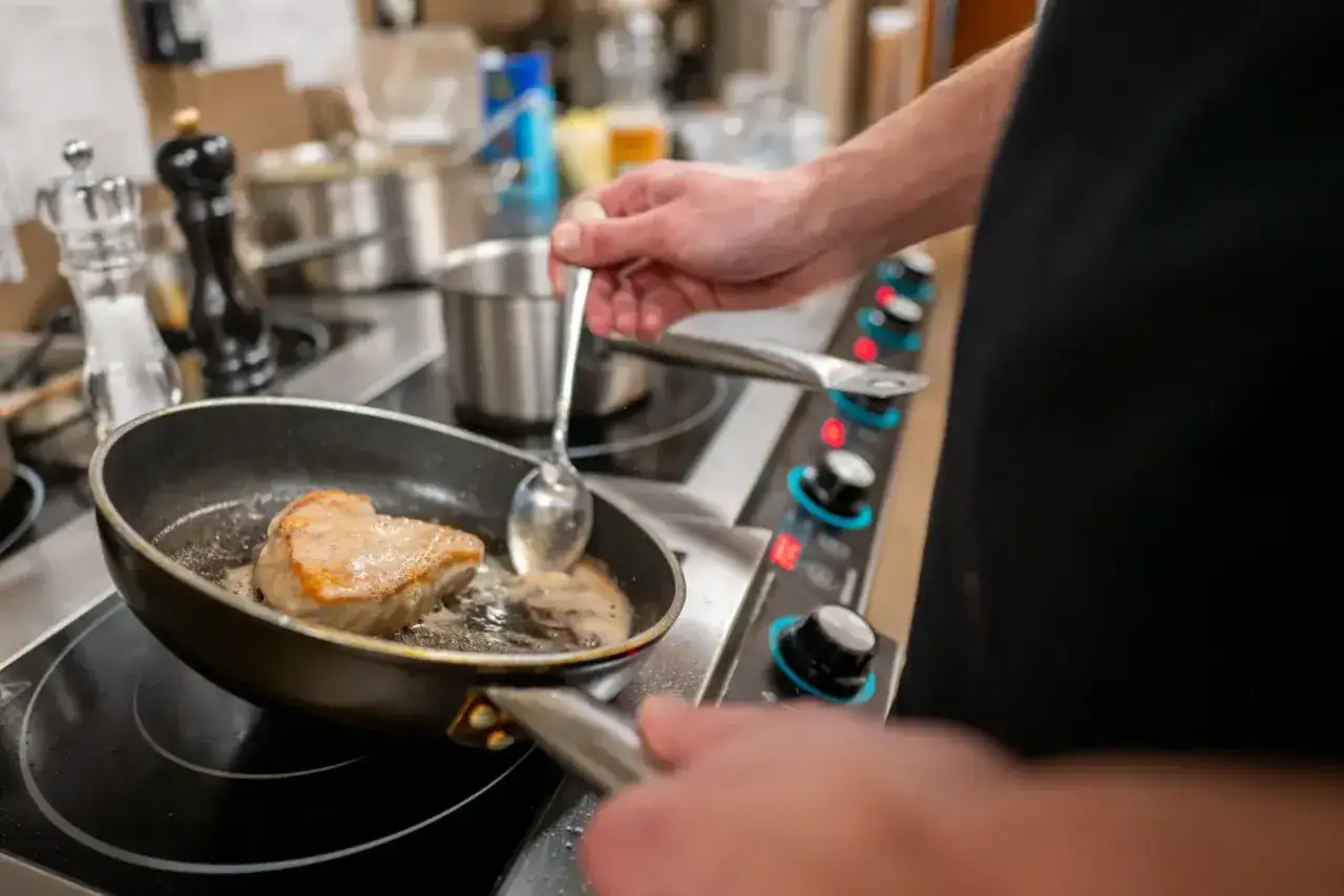 Szef kuchni smaży wołowinę na patelni, zastanawiając się, kiedy solić wołowinę, by uzyskać idealny smak.