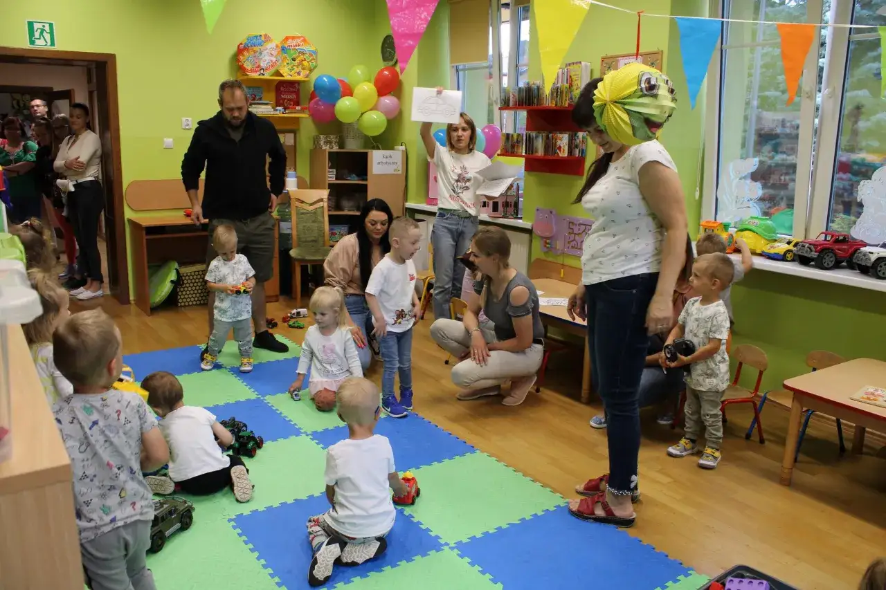 Dzieci i dorośli na dniach otwartych w przedszkolu. Wesołe dekoracje, zabawy i pomysły na kreatywne zajęcia.