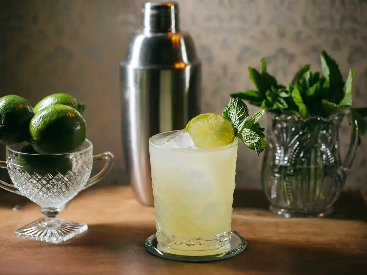 Gotowe składniki do drinka: limonki, świeża mięta, shaker. Idealne na to, jak zrobić mohito.