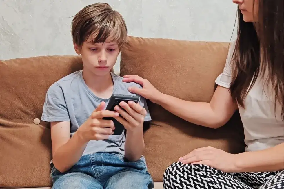 Rodzic kontrolujący telefon dziecka, bezpieczne korzystanie z internetu przez dzieci