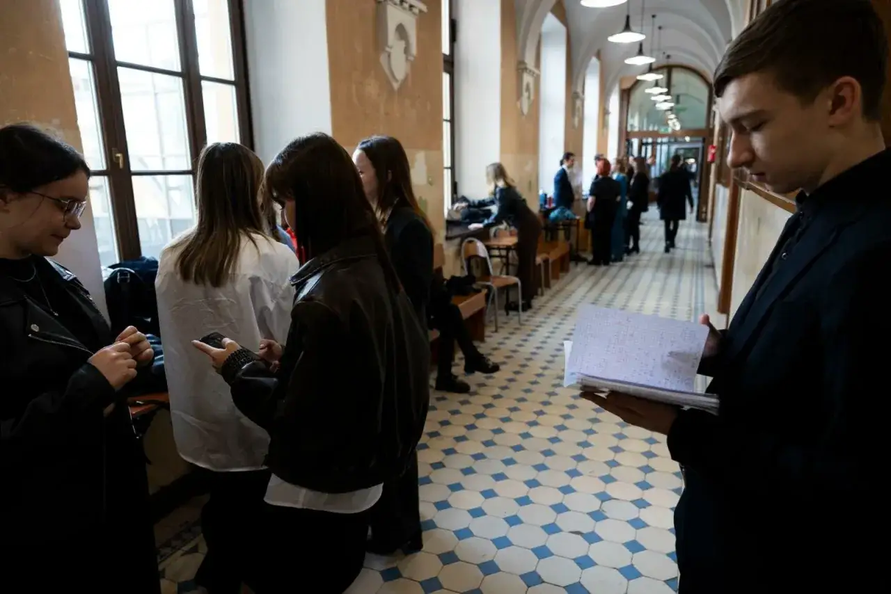 Uczniowie czekają na matura ustna angielski rozszerzony. Jeden z nich przegląda notatki.