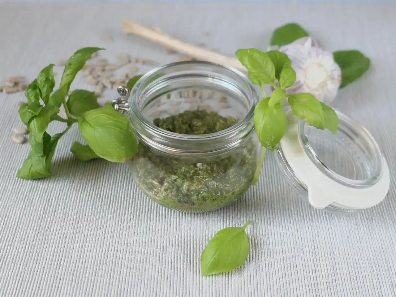 Słoik z zielonym pesto, świeża bazylia i czosnek. Tak wygląda pyszne pesto!