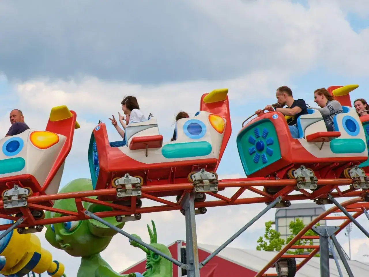 Wesołe wagoniki kolejki górskiej z pasażerami, świetne atrakcje dla dzieci nad morzem.