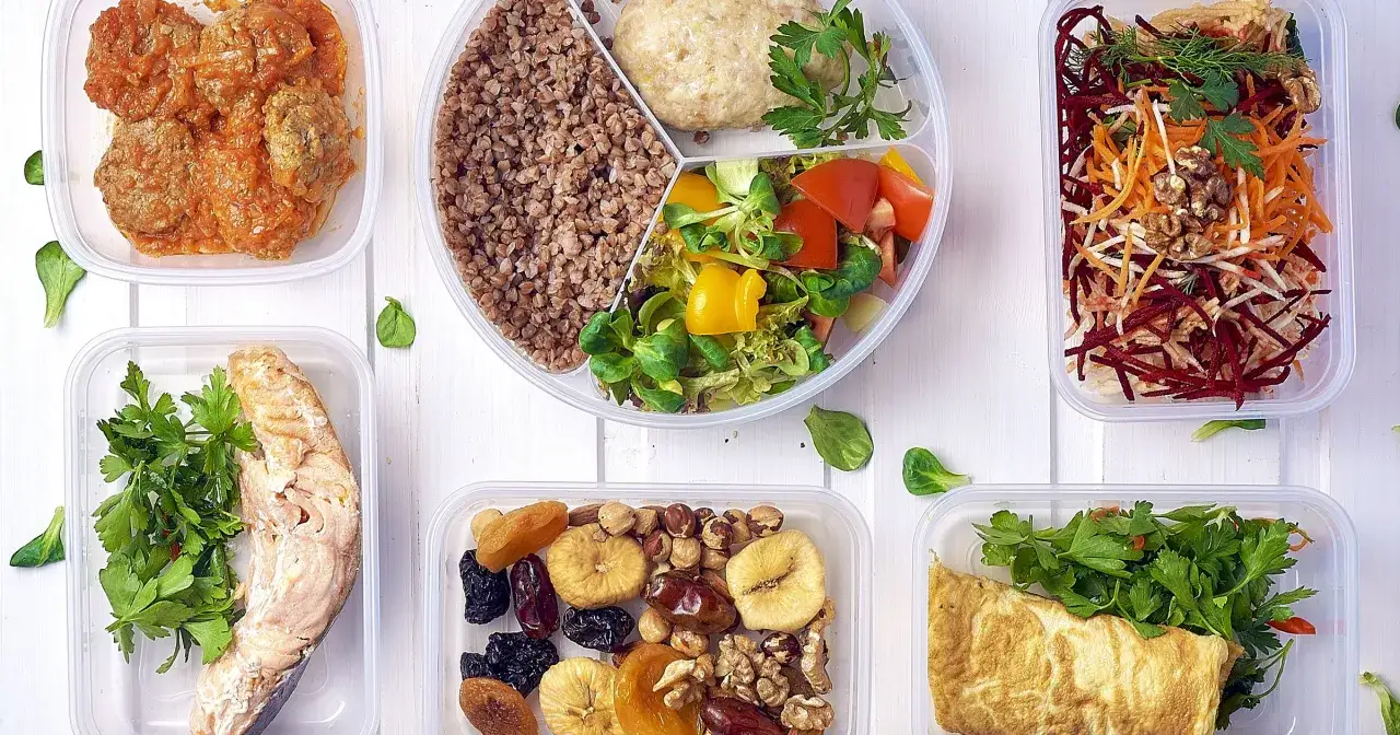 Czy catering dietetyczny się opłaca? Zobacz r&oacute;żnorodne, zdrowe posiłki w pojemnikach: ryba, mięso, sałatki, kasza, omlet i suszone owoce z orzechami.