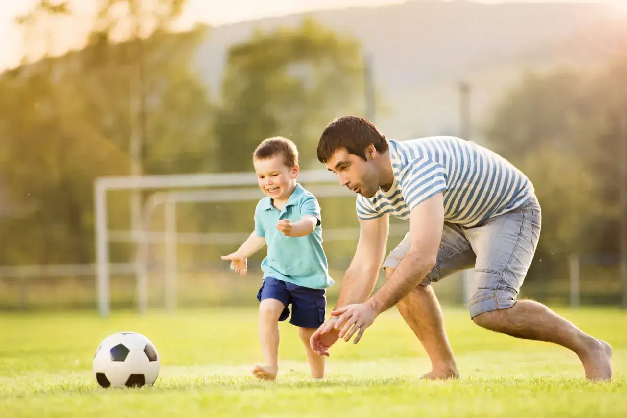 rodzic wspierający dziecko na meczu piłki nożnej
