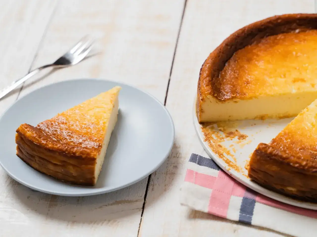 Idealny moment, kiedy sernik jest upieczony: złocisty, pachnący, z apetycznym kawałkiem na talerzu.