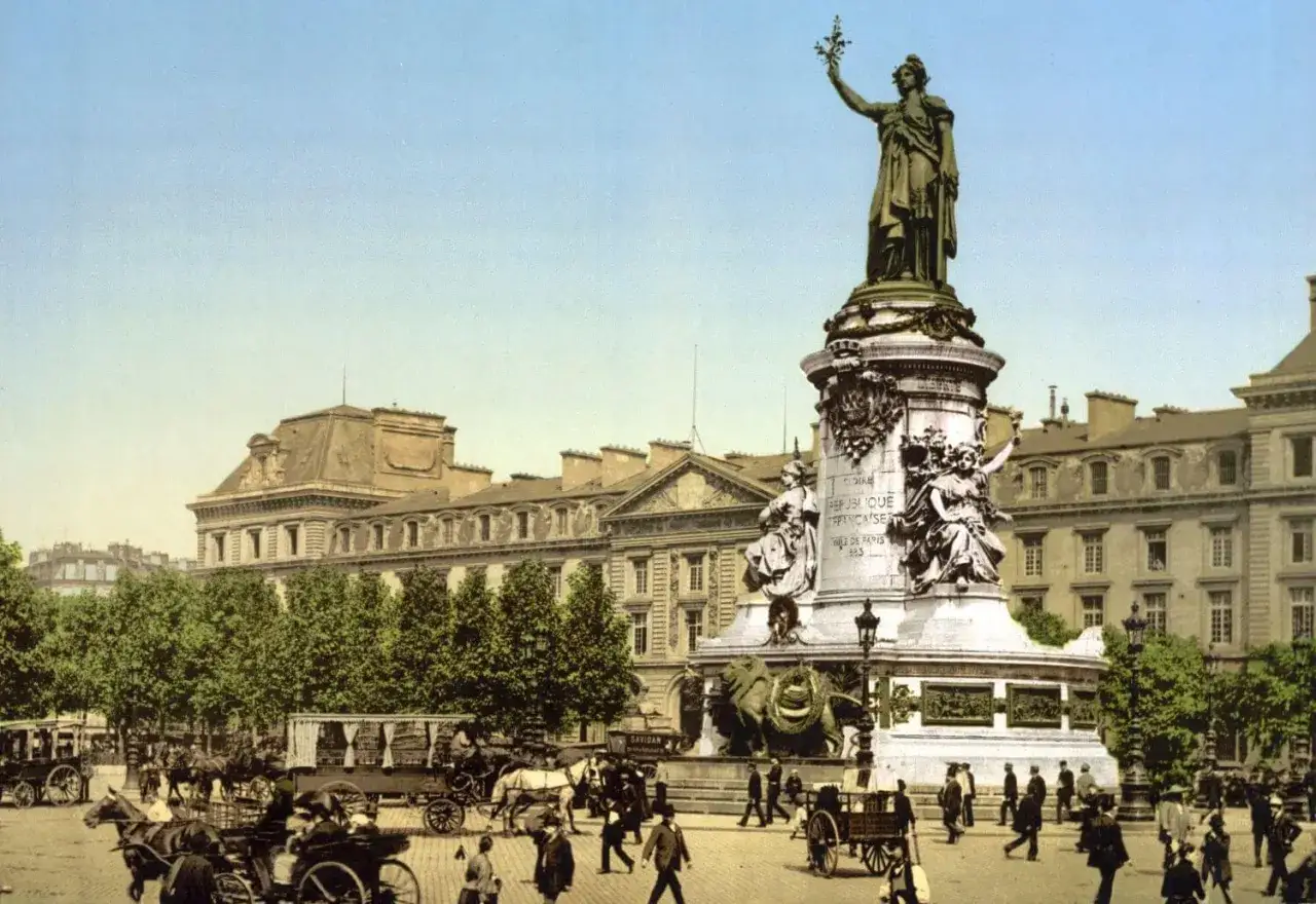 Pomnik Republiki na Placu Narodu, serce 10 dzielnicy Paryża. Ludzie spacerują, wozy konne w ruchu.