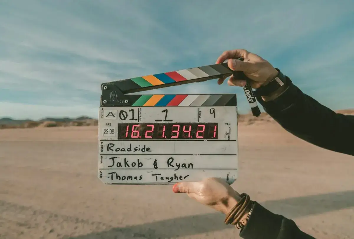 Klapka filmowa z napisem "Roadside", sceną 1, ujęciem 9. To opis filmu po angielsku, gotowy do rozpoczęcia zdjęć.