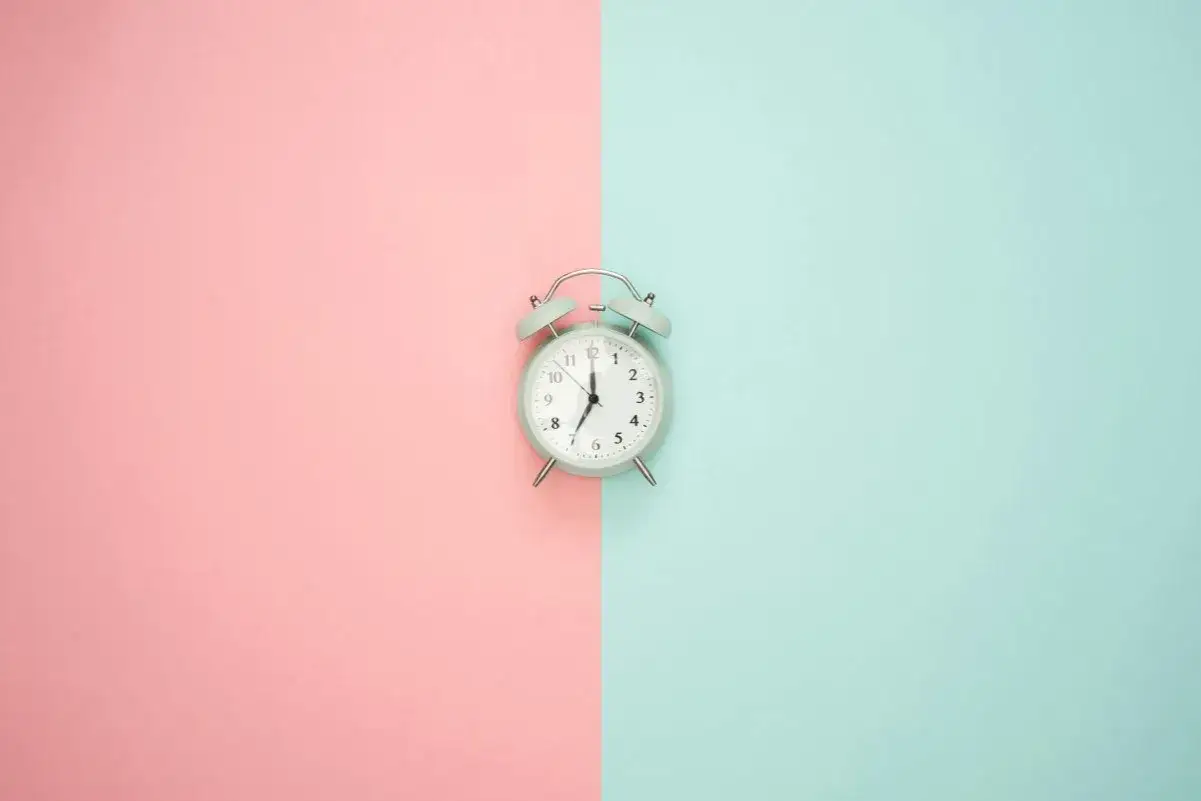 Budzik na pastelowym tle. Pokazuje 7:00, czas na rozpoczęcie dnia, czy to am, czy pm, zawsze jest dobry moment na zmianę.