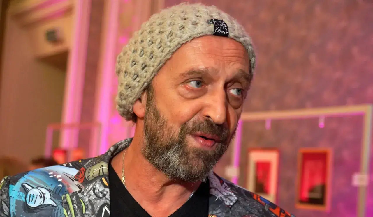 Nikodem Chabior w beżowej czapce i kolorowej kurtce, z zarostem, patrzy w bok.