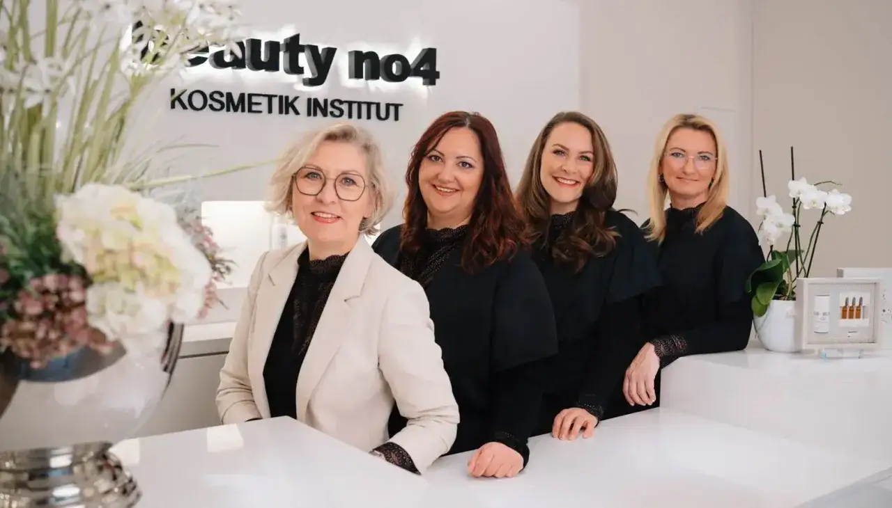 Vier freundliche Frauen im "Beauty no4 Kosmetik Institut" lächeln in die Kamera. Sie sind bereit, Ihnen mit Kosmetik und Wellness zu verwöhnen.