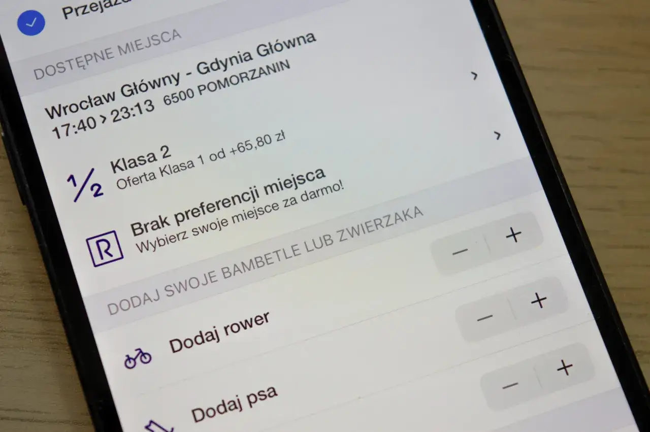Ekran telefonu z aplikacją do rezerwacji miejsc w pociągu, pokazujący dostępne opcje.