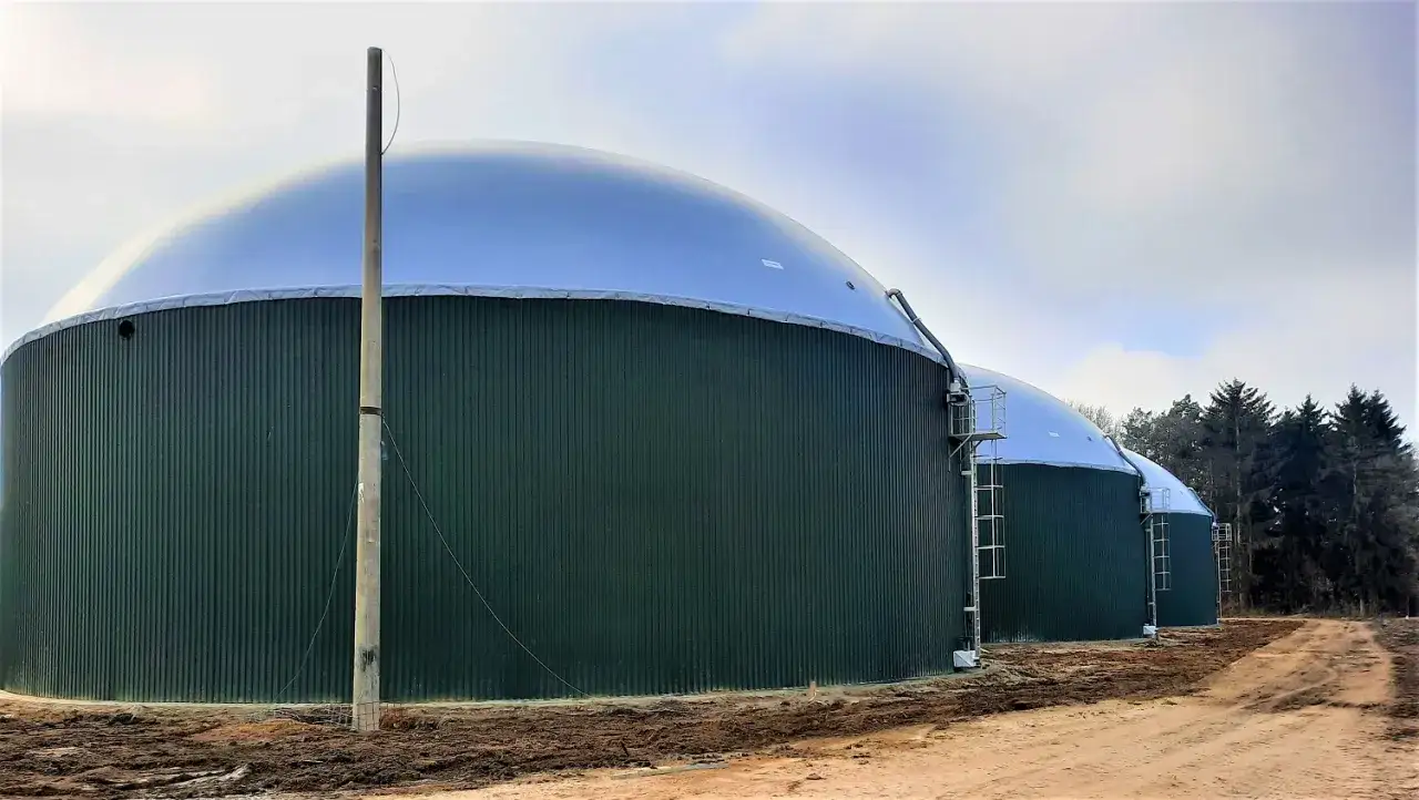 Zielone, cylindryczne zbiorniki z kopułami to biogazownia, gdzie powstaje energia z biomasy.