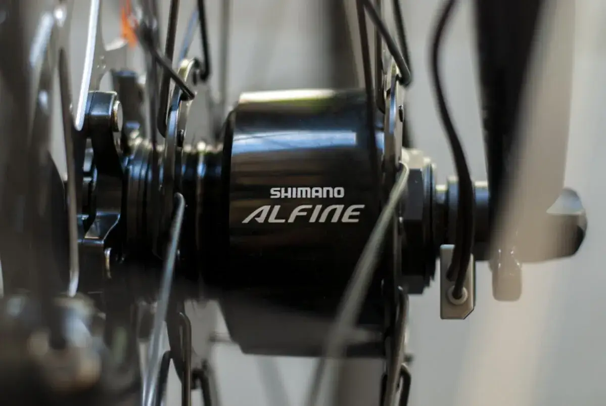 Szczegół piasty rowerowej Shimano Alfine z widocznym kablem, który jest kluczowy, by dowiedzieć się jak włączyć dynamo w rowerze.