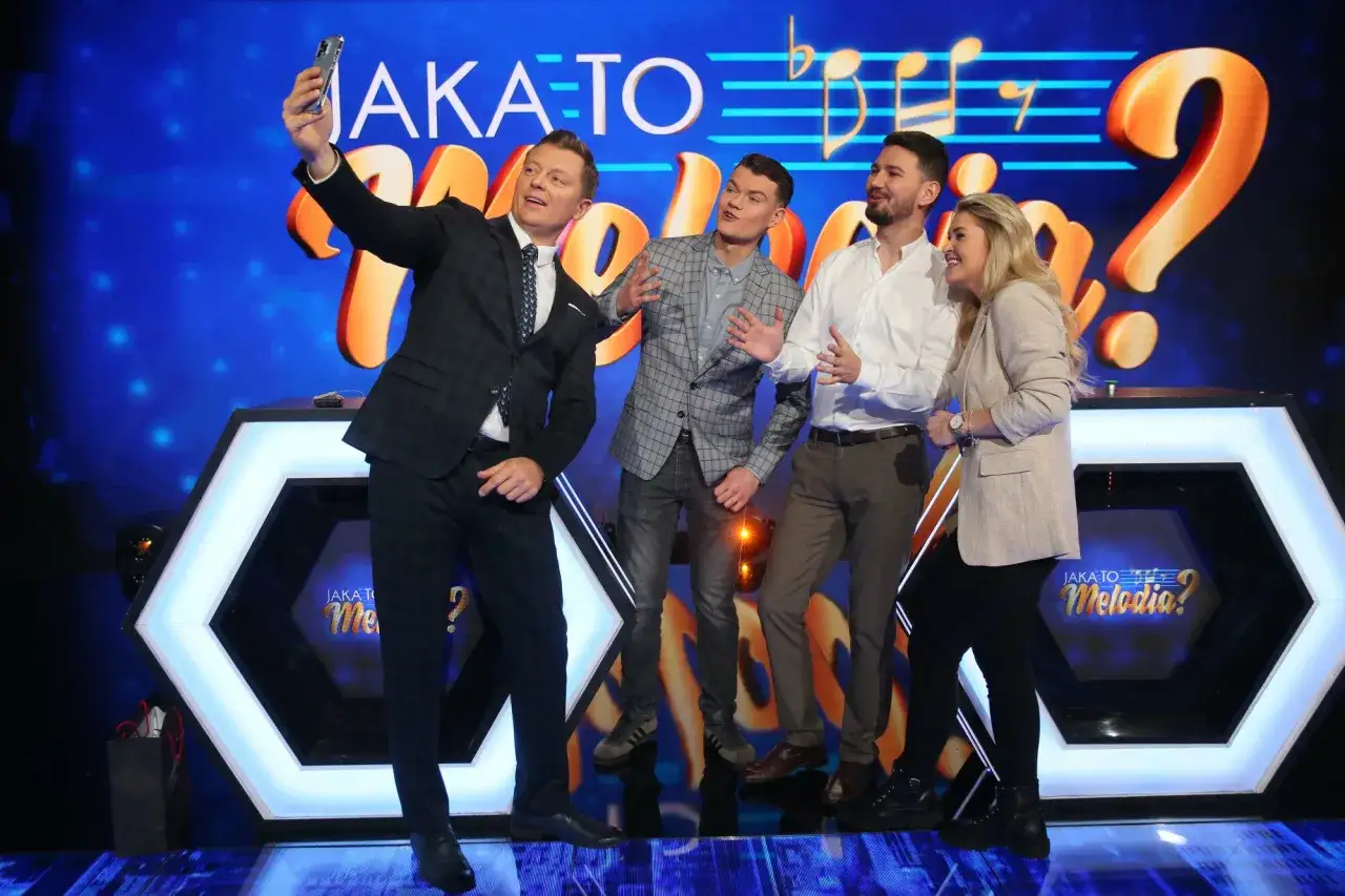 Jaka to melodia obsada robi sobie selfie. Uśmiechnięci uczestnicy pozują na tle scenografii z logotypem programu.