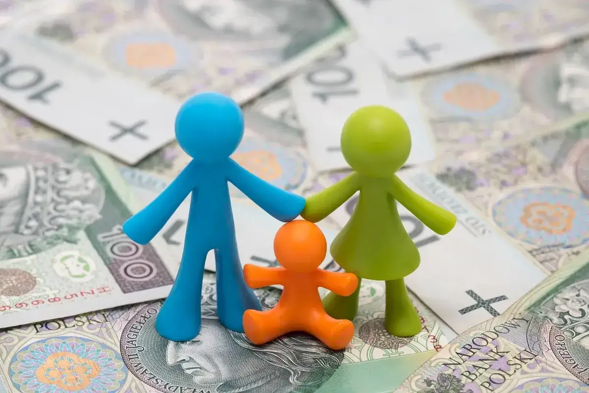 Rodzina z figurkami na tle polskich banknotów. Jaki dochód do rodzinnego budżetu?