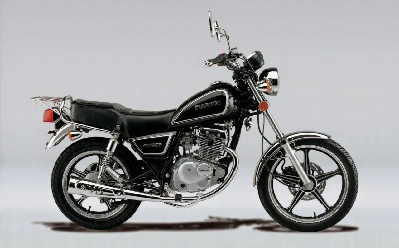 Czarny motocykl Suzuki GN 125 z chromowanymi elementami, siedzeniem pasażera i bagażnikiem.
