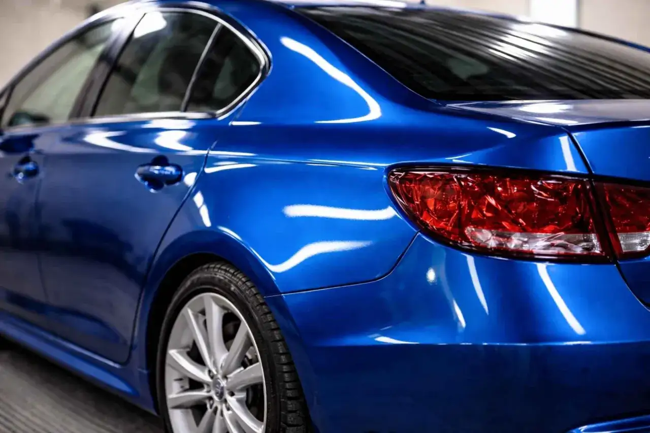 Błyszczący, niebieski zderzak w kolorze auta, gotowy do montażu, w przeciwieństwie do zderzaka do malowania.