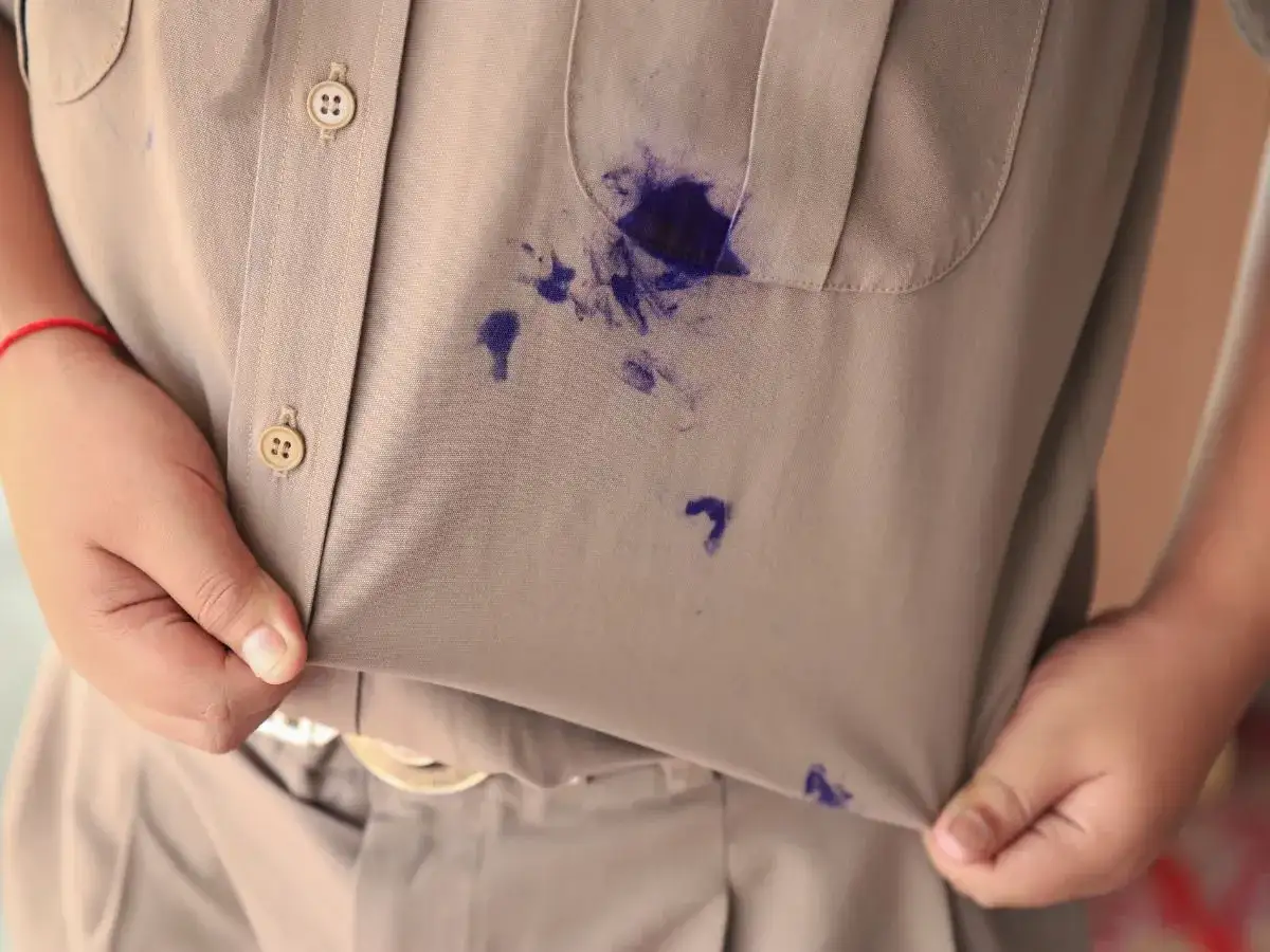 Plama z długopisu na beżowej bluzce. Jak zmyć długopis z bluzki? Szybka pomoc w usunięciu plam.