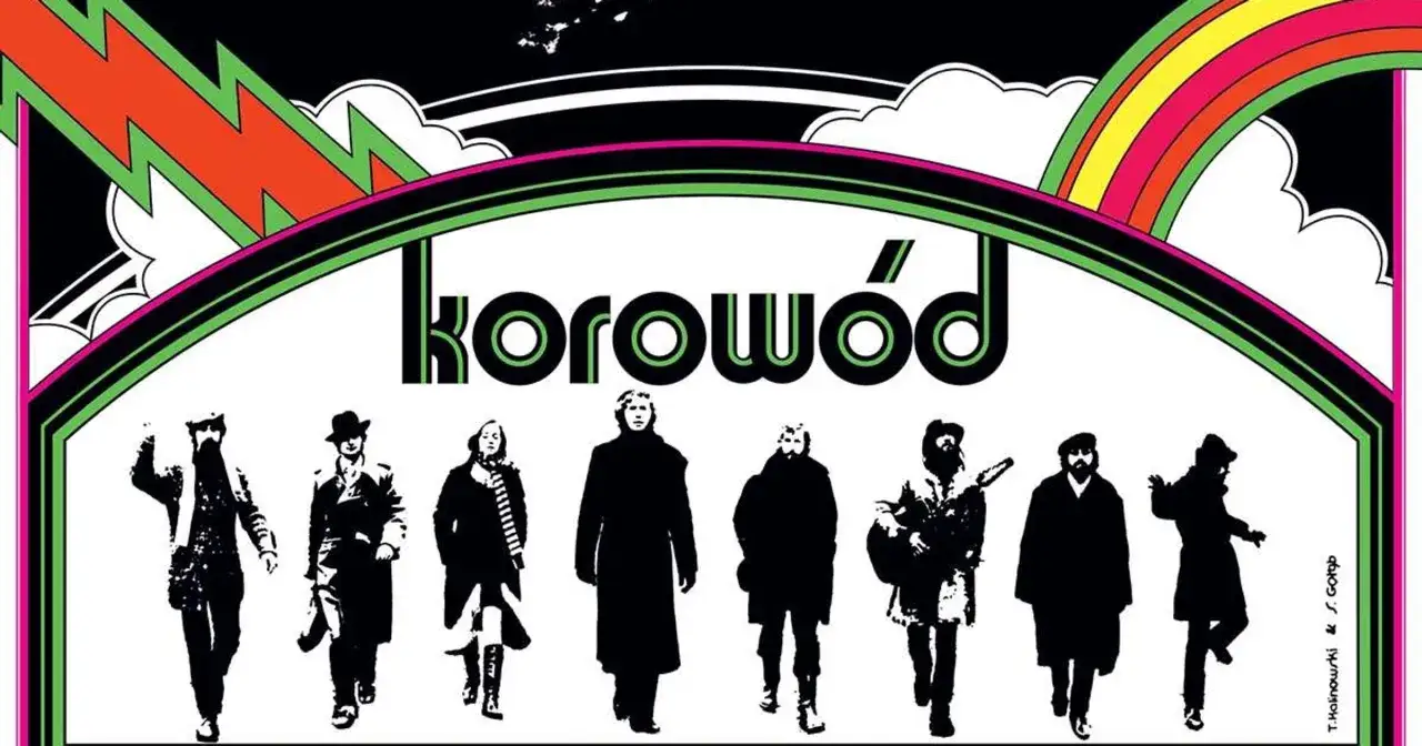 Grupa ludzi w czerni, jakby z dwóch morgi słońca, idzie pod tęczą. Napis "korowód" sugeruje, że to oni śpiewają.