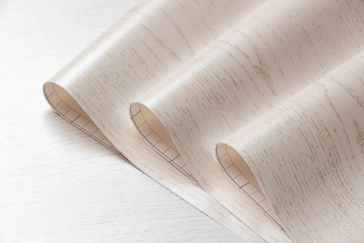 Rolka tapety winylowej imitującej drewno, z siatką na spodzie, idealna do nauki jak usunąć starą tapetę winylową.