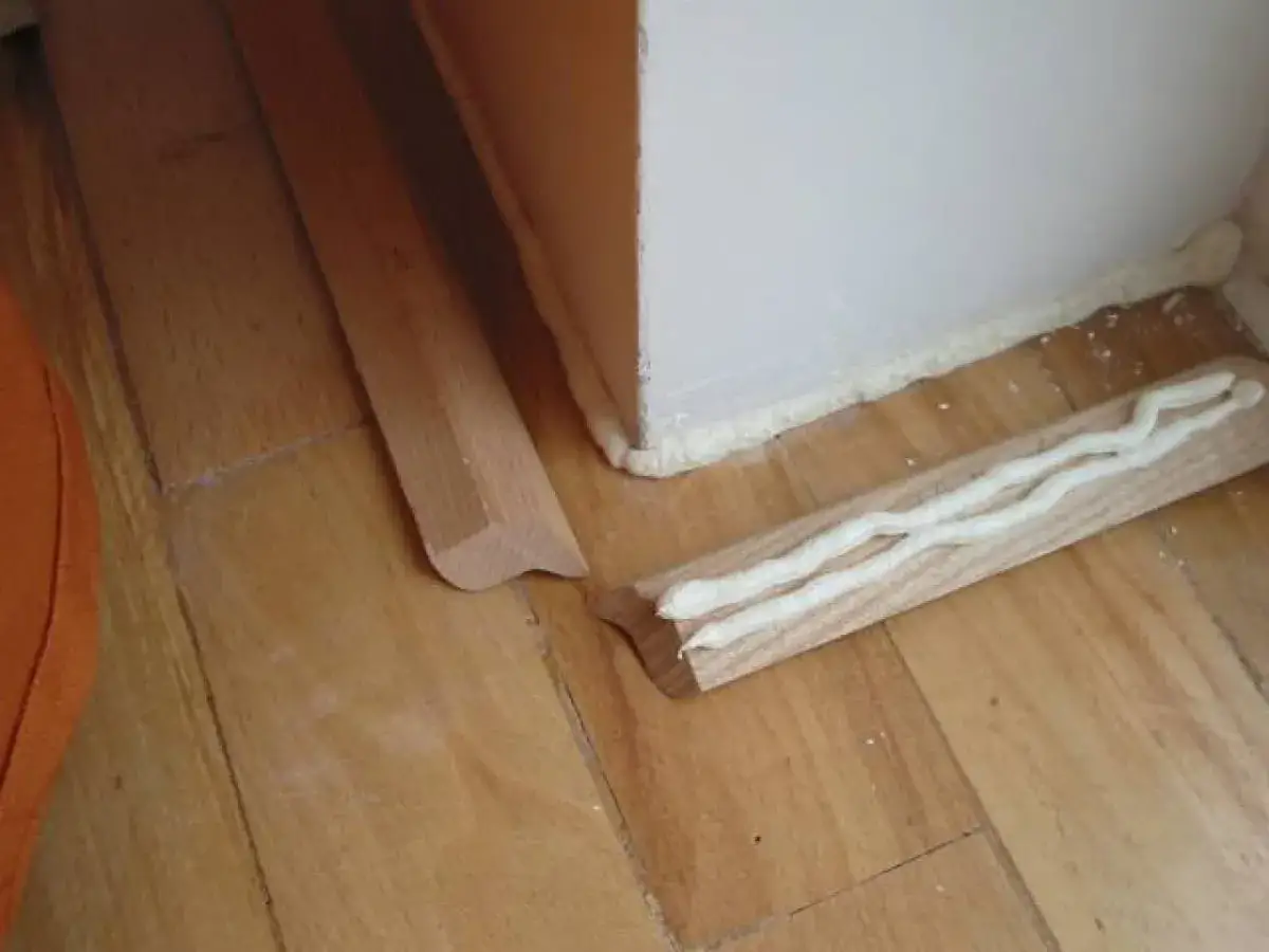 Drewniane listwy przypodłogowe z nałożonym klejem montażowym.