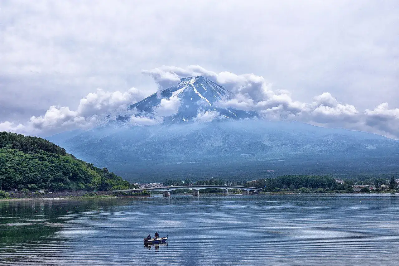 Góra Fudżi nad jeziorem, most i łódka. Zastanawiasz się, ile trwa lot do Japonii z Katowic?
