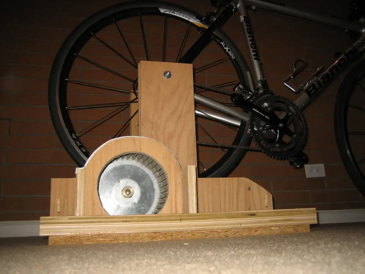 Domowy trenażer do roweru z wentylatorem i drewnianą ramą. Idealny do ćwiczeń w domu, gdy nie możesz wyjść na zewnątrz.