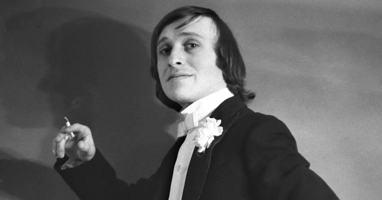 Mężczyzna w garniturze z butonierką i cygaretą w dłoni. Naprawdę jaka jesteś nie wie nikt, kto śpiewa, ale jego spojrzenie mówi wiele.