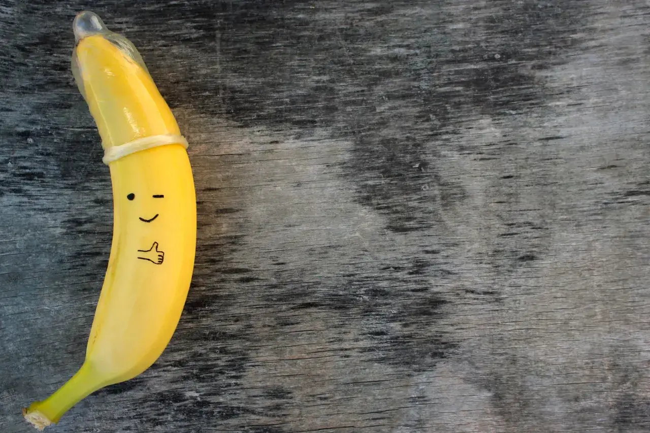 Banan w prezerwatywie, z namalowaną buźką i kciukiem w górę. To zabawne przypomnienie, co to kondomy i jak ważne są w ochronie.