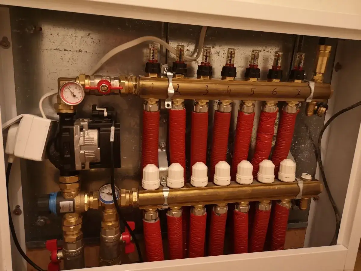 Rozdzielacz podłogówki z pompą i przepływomierzami. Sprawdź, jak zwiększyć przepływ w podłogówce, regulując zawory i przepływ.