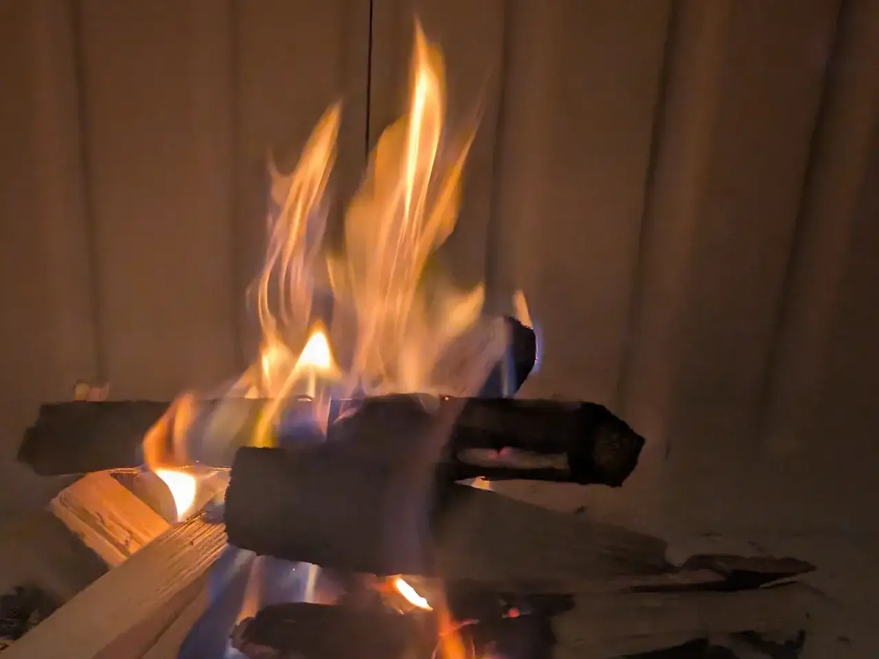 Płonące drewno w kominku. Warto wiedzieć, do kiedy można palić drewnem, by cieszyć się ciepłem.