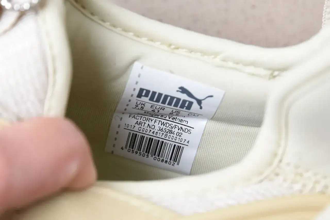 Oryginalna metka Puma na jasnej podeszwie buta, z informacjami o rozmiarze i pochodzeniu.