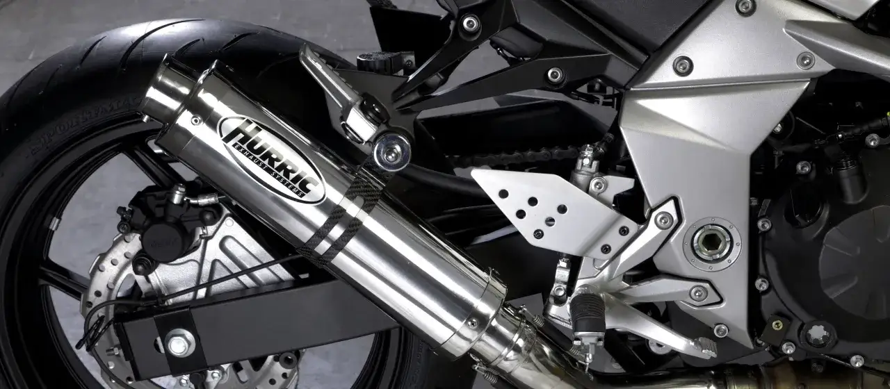 Błyszczący tłumik motocyklowy Hurric, element układu wydechowego, który może pomóc w uzyskaniu basowego brzmienia.