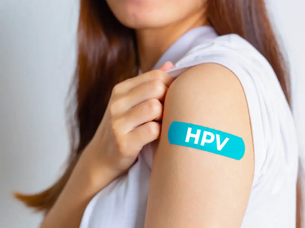 Ramię z plastrem z napisem HPV. Po szczepieniu mam HPV, co z seksem? Bezpieczeństwo przede wszystkim.