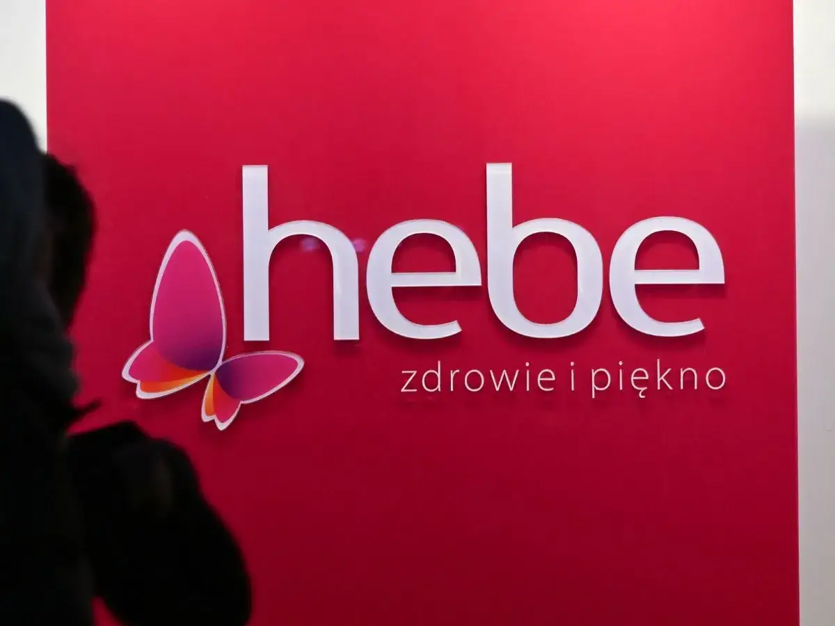 Logo Hebe z motylem na czerwonym tle.