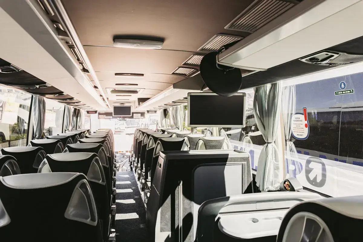 Wnętrze autokaru z wygodnymi siedzeniami, idealne na podróż do Nowego Targu w Bukowinie Tatrzańskiej.