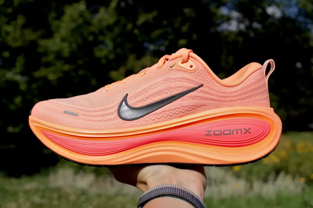 Pomarańczowy but do biegania Nike z czarnym logo i podeszwą ZoomX.