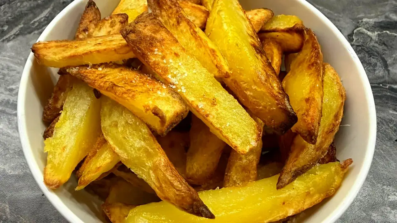 Złociste, chrupiące frytki w misce. Idealne do smażenia na głębokim tłuszczu lub pieczenia.