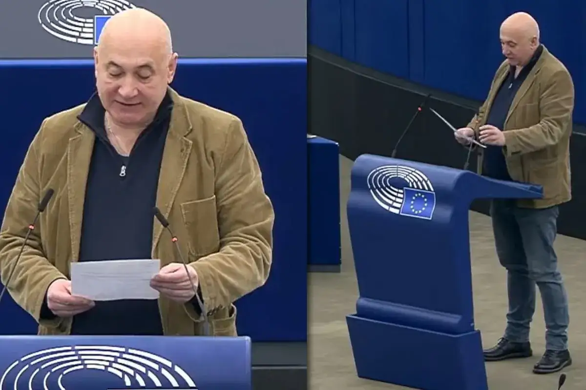 Polscy europosłowie lista: mężczyzna w brązowej marynarce przemawia w Parlamencie Europejskim, trzymając dokument.