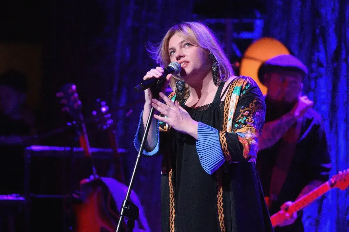 Anna Dąbrowska śpiewa na scenie. Koncert trwa, a fani zastanawiają się, ile trwa koncert Ani Dąbrowskiej.