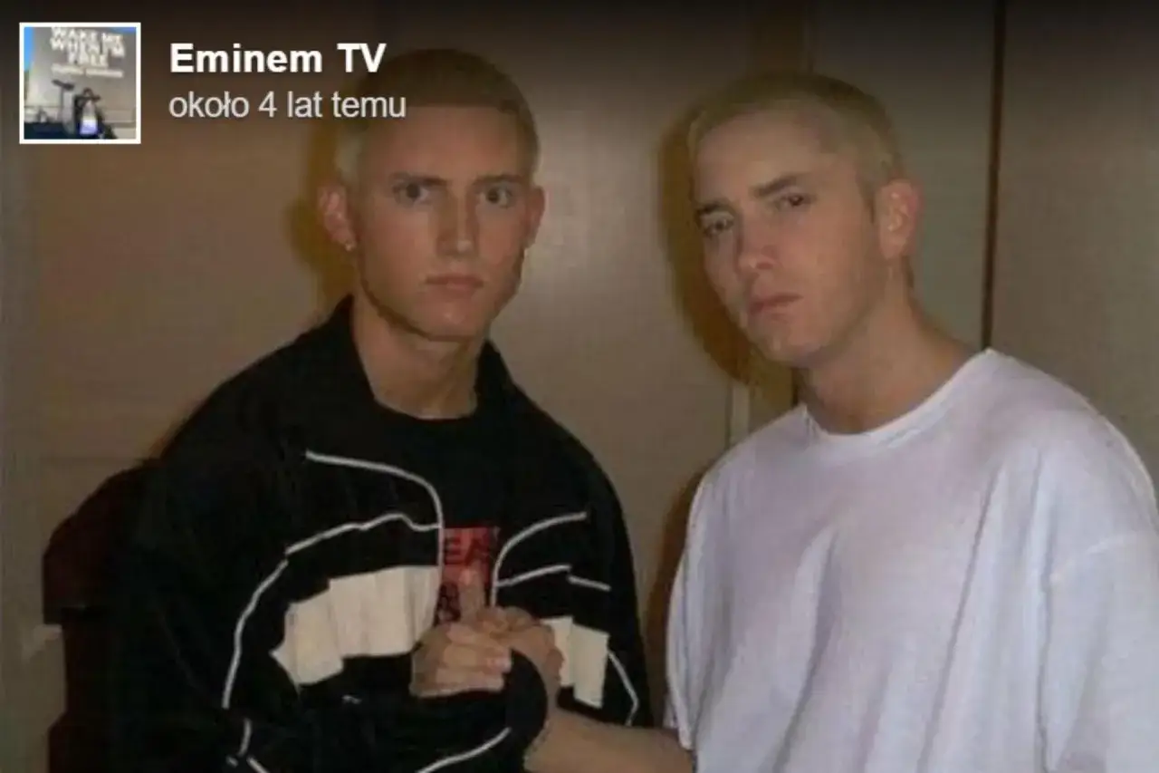 Dwóch młodych mężczyzn, jeden w czarnej bluzie, drugi w białej koszulce, pozuje do zdjęcia. Czy eminem żyje? Tak, ten artysta ma się dobrze.